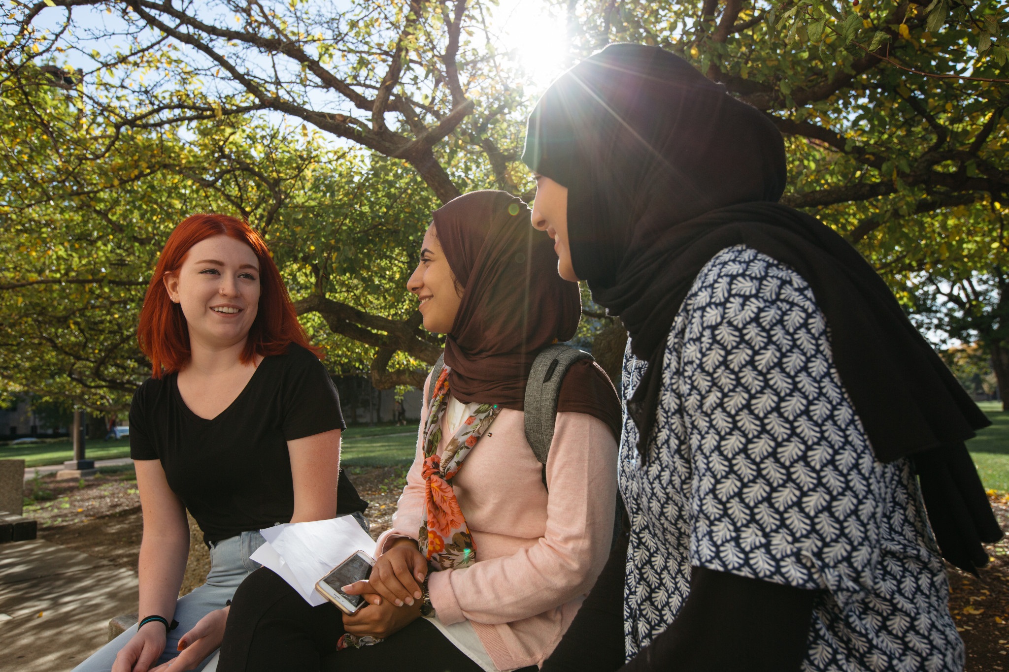 Three students are sitting and chatting